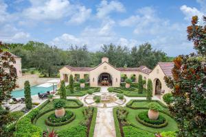 Landscaped grounds inspired by French design with a covered walkway that wraps around the backyard.