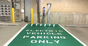 Redwood Capital Group and Redwood Residential have installed a new luxury amenity for residents at Deer Park Crossing Apartments SemaConnect Series 6 EV charging station with cable management system mounted on parking garage wall at Chicago's Deer Park Crossing Apartments