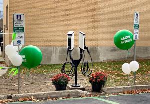 The Pend Oreille Public Utility District has added another service for residents in Pend Oreille County SemaConnect Series 6 smart networked EV charging stations on dual pedestal with green Grand Opening balloons at Pend Oreille PUD's Newport Administration Building