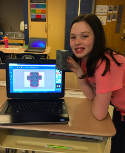 Girl student holds box she designed using the Engineering Design Process and FabMaker software to prototype her invention.
