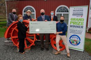 Investors Bank and the companies co-sponsoring the Movers & Shakers Small Business Competition recently selected the two grand prize winners Photo of check presentation, six people stand by an old orange tractor. Three people in front row are holding a large check.