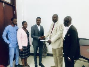 Professor Seth Owusu-Agyei handing documents to Mr Rudolf Schirmer Ampofo-Domfeh,CEO of Augson Global